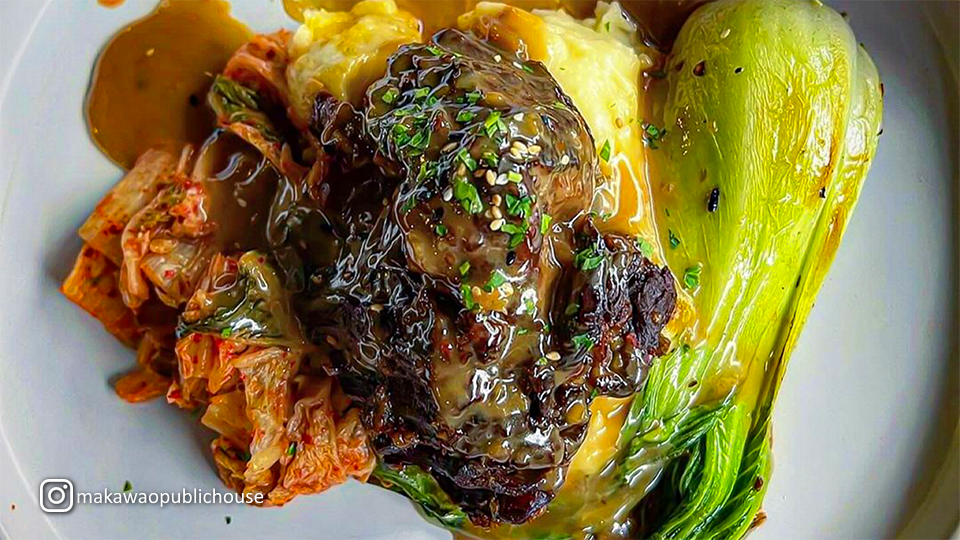 Plate of Kalbi Braised Short Ribs at Makawao Public House in Makawao, Maui, served with vegetables and a savory glaze.