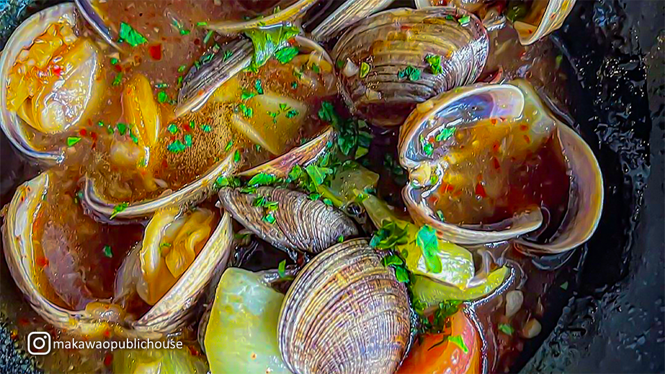 Close-up of oysters at Makawao Public House, served in a sauce.