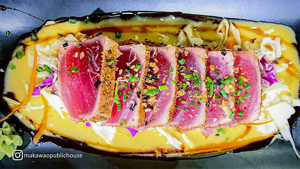 Plate of seared sashimi at Makawao Public House, showcasing delicately seared slices of fresh fish with garnishes.