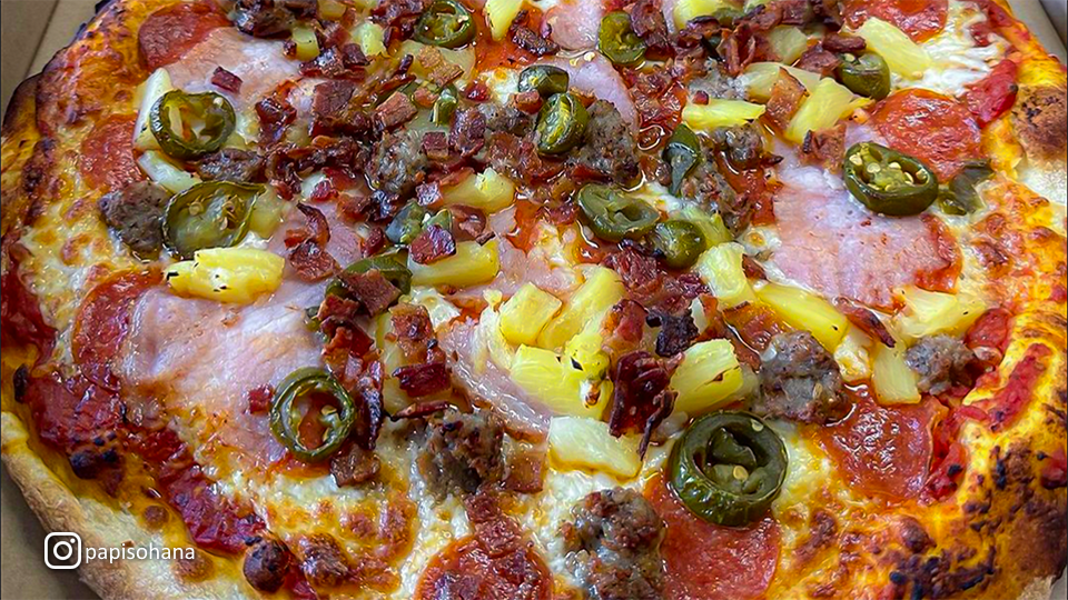 Mouth-watering pizza at Papi’s Ohana, topped with fresh ingredients and melted cheese.