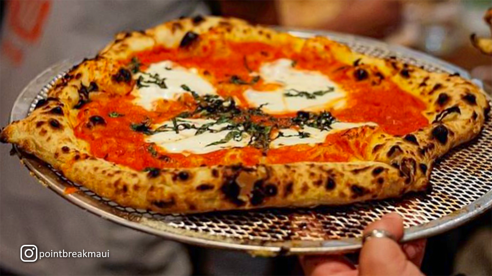 Close-up of a Margherita pizza at Point Break Pizza & Panini, featuring fresh basil, tomato sauce, and melted mozzarella cheese.