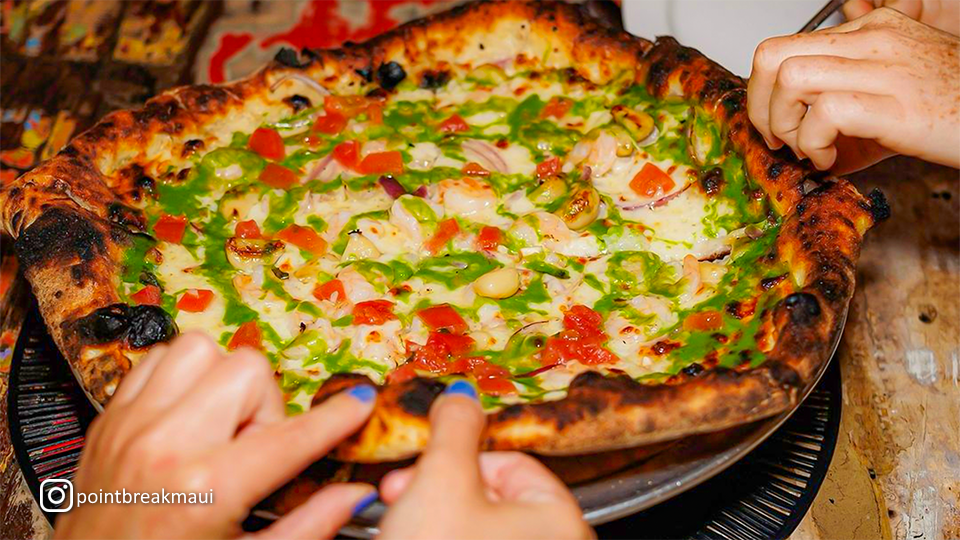 Garden of Eats pizza at Point Break Pizza & Panini, topped with a variety of fresh vegetables and herbs on a crispy crust.