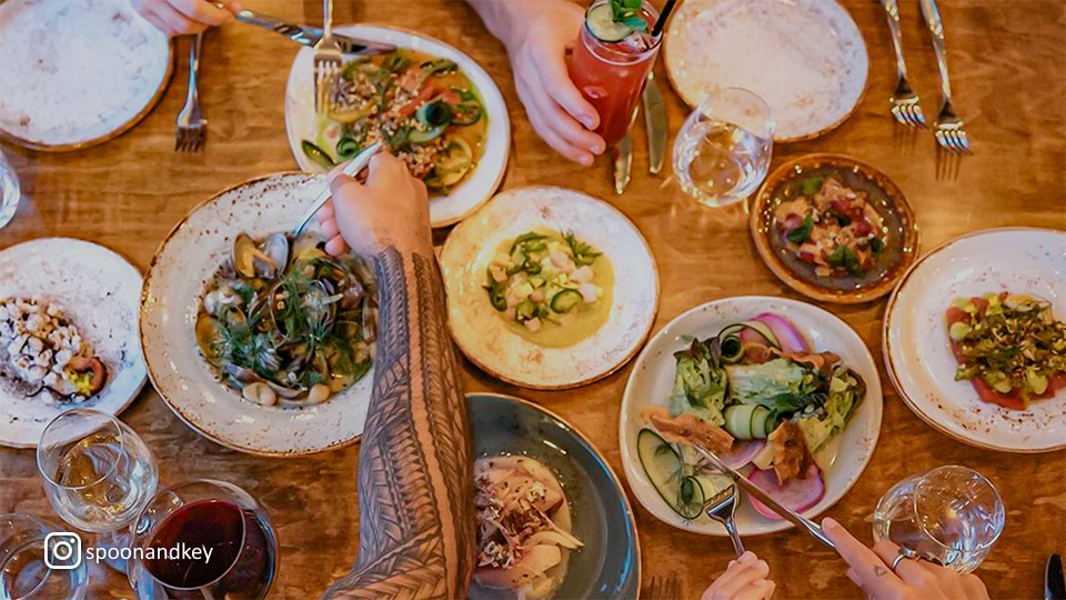 Aerial view of multiple plates with unique dishes and garnishes at Spoon & Key Market, showcasing a variety of textures and flavors.