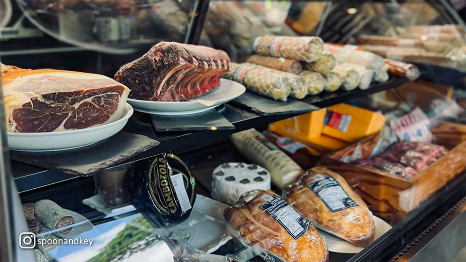 Cold cuts on display at Spoon & Key Market, featuring a selection of meats and cheeses arranged for customers.