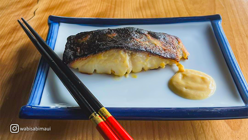 Plate of seared Gindara Saikyo-Yaki (Miso-Marinated Black Cod) with sauce and chopsticks at Wabisabi Soba & Sushi.