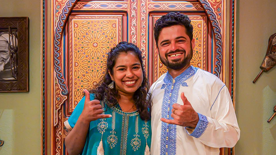 Two people posing at Le Bazaar Maui with shaka hand symbols, showing aloha and positivity.