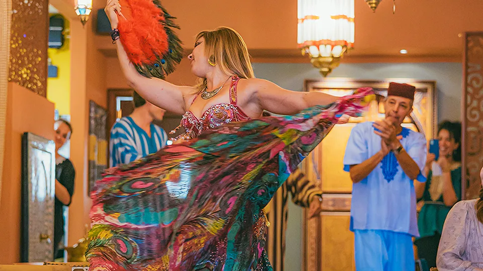 Woman dancing at Le Bazaar Maui, performing a traditional dance with graceful movements.