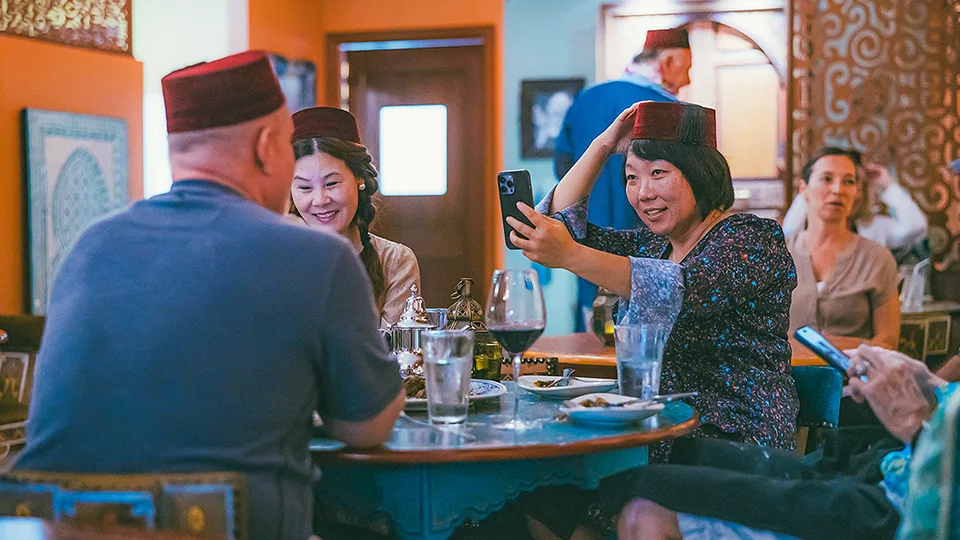 Group of guests sitting at a table at Le Bazaar Maui, enjoying their dining experience and conversation.