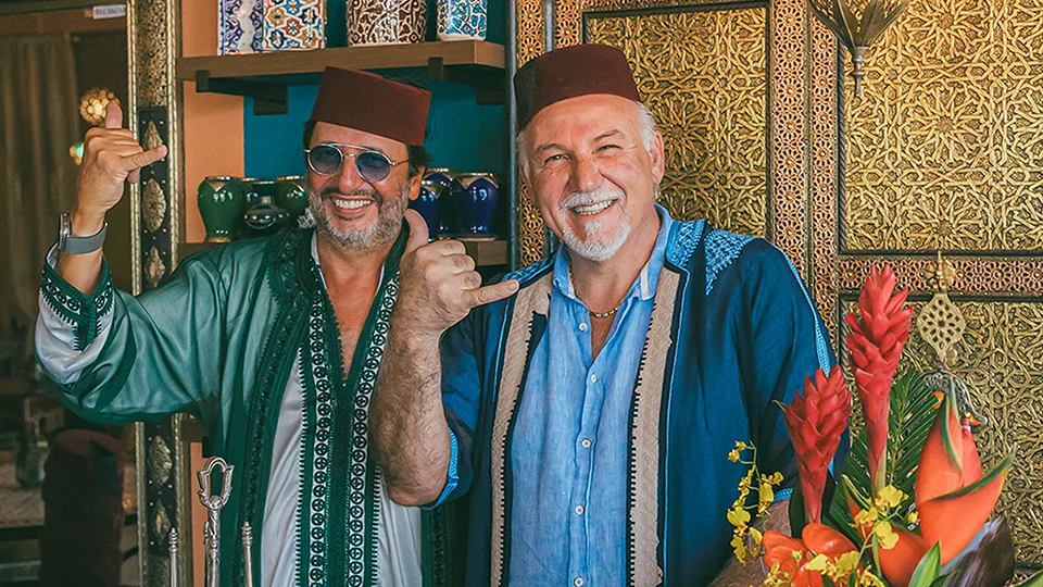 Two people at Le Bazaar Maui, smiling and making shaka gestures for the camera.