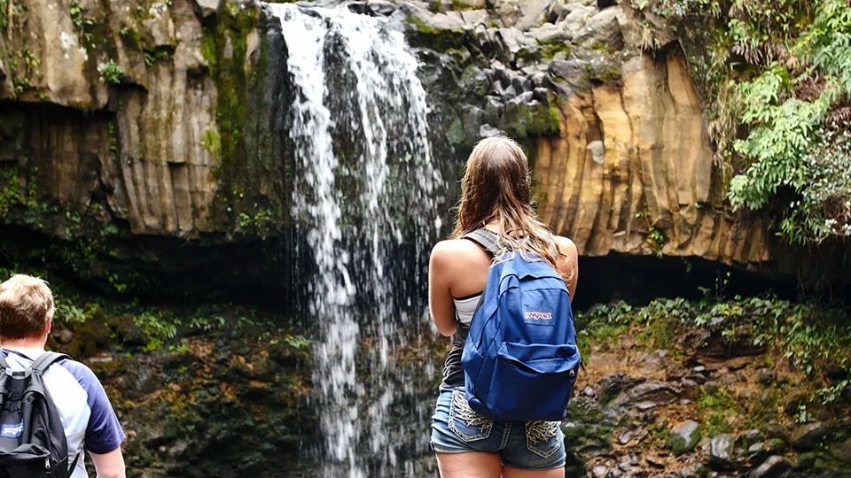 Visitor enjoying Twin Falls waterfall pool along family-friendly trail first major waterfall on Road to Hana