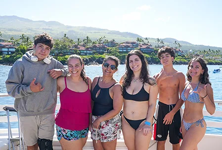 Pride of Maui boat hosting community heroes from Papi's 'Ohana and Maui Food Bank with Maui coastline in background