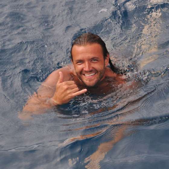 A man swimming and giving a shaka